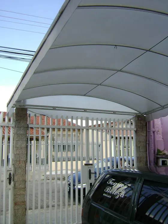 Cobertura curva em lona sobre portão de garagem