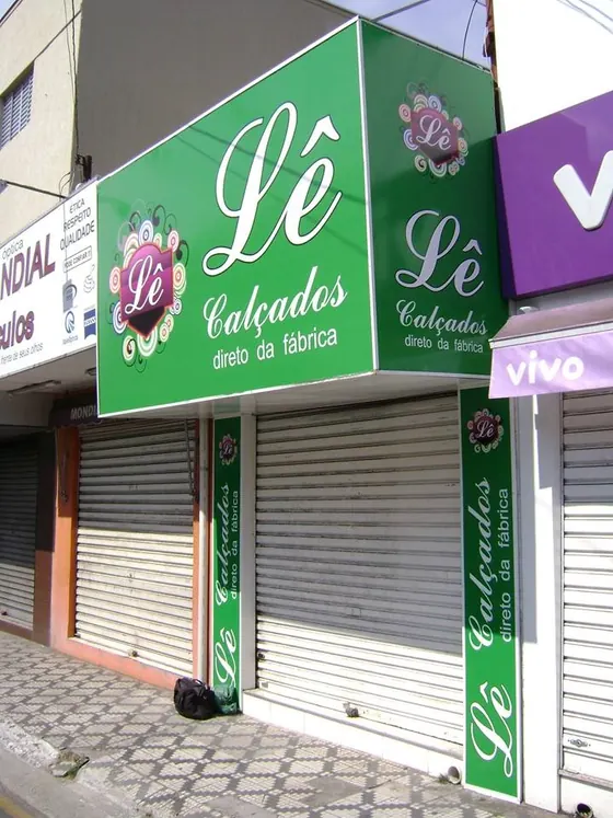 Fachada vertical em loja de calçados, com placa e letreiro