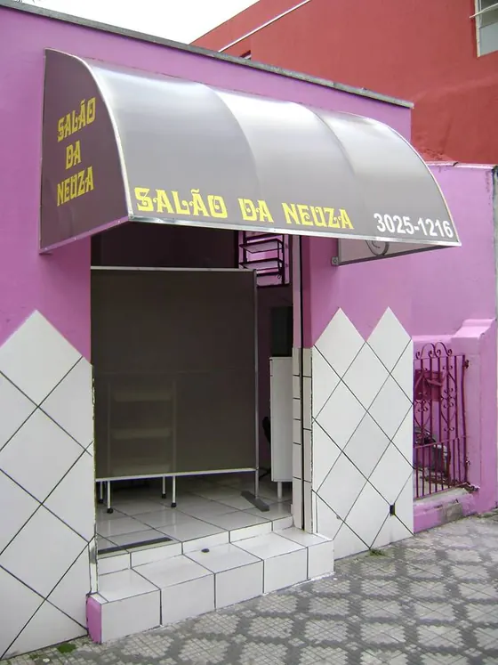 Toldo modelo capota em lona sobre entrada de salão