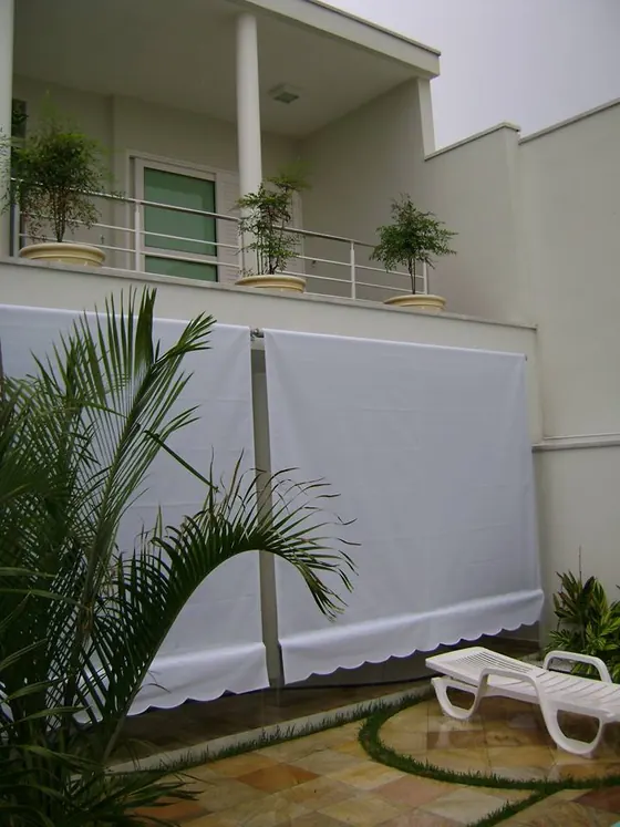 Toldo cortina em residência, protegendo a varanda do sol